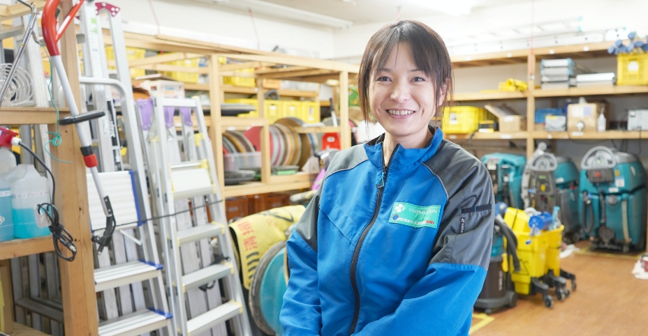 清掃道具が並ぶ作業場に立つ社員