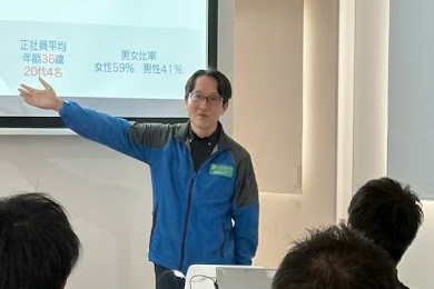 教室で画面を指さして説明する社員